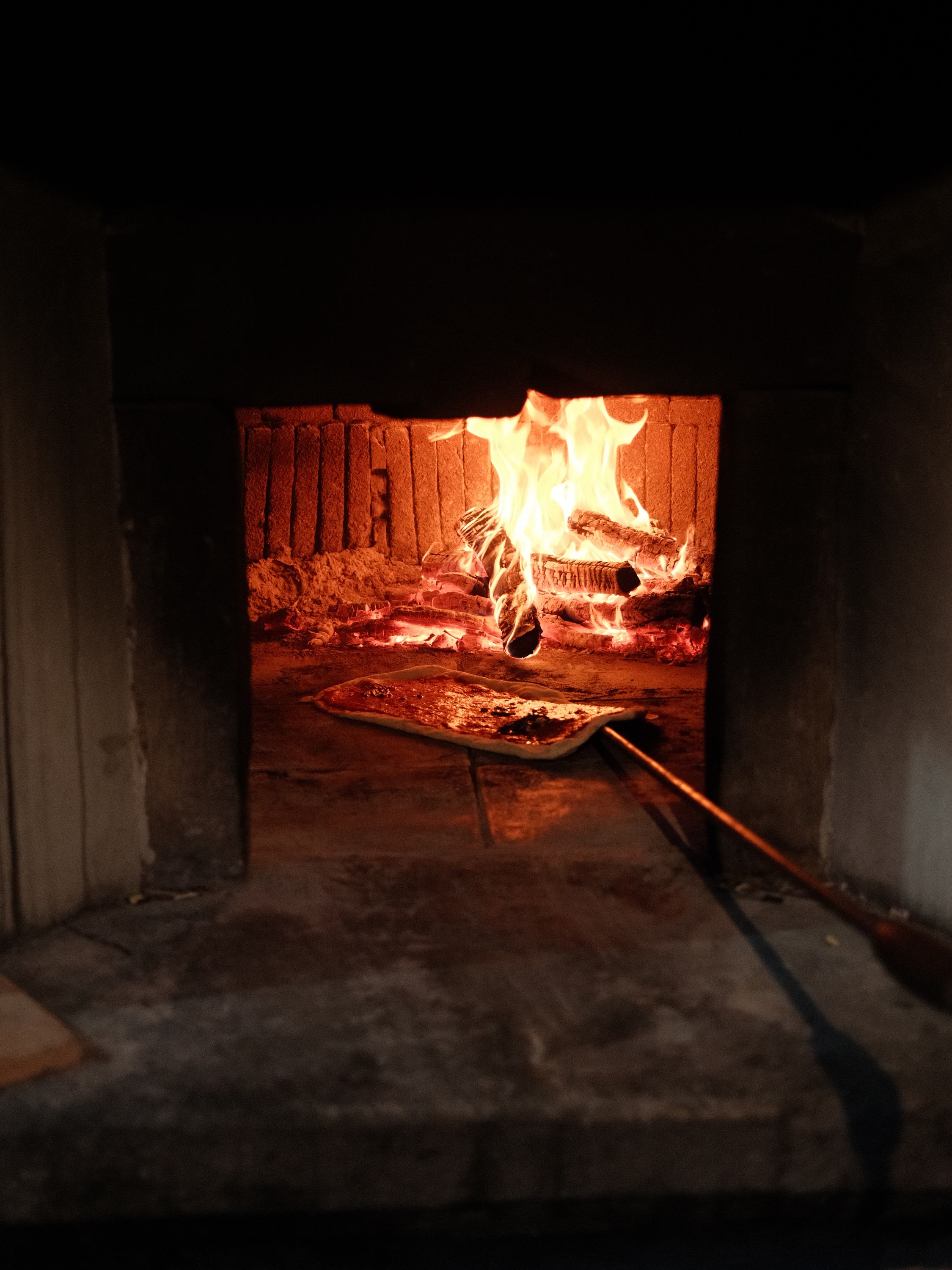 Pizza going into the villa's wood-fired oven